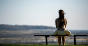 young woman sitting on a bench and thinking